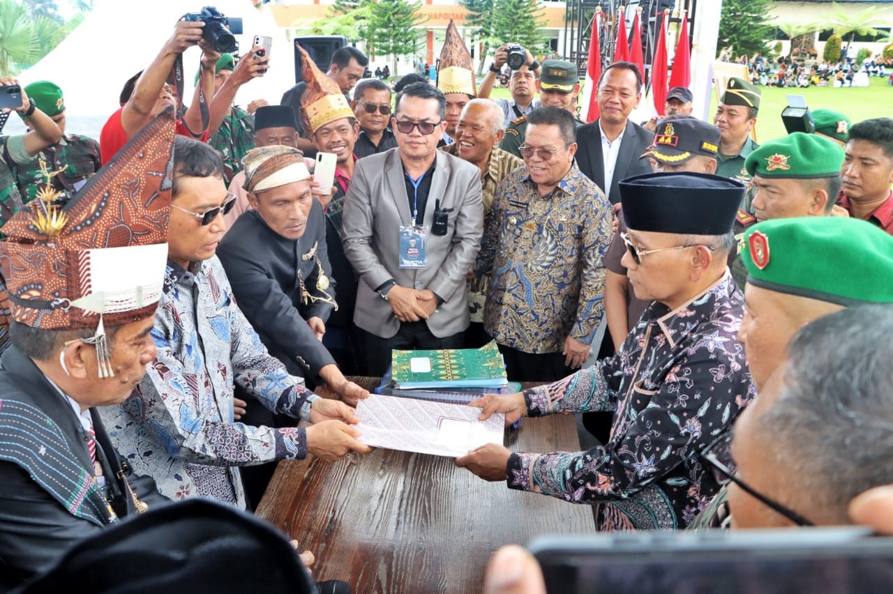 Bupati Simalungun, Dr h Anton Ahmad Saragih (kanan) menerima simbol-simbol Pahlawan Nasional Tuan Rondahaim dari ahli waris Dr. Jr Saragih, SH, MM.