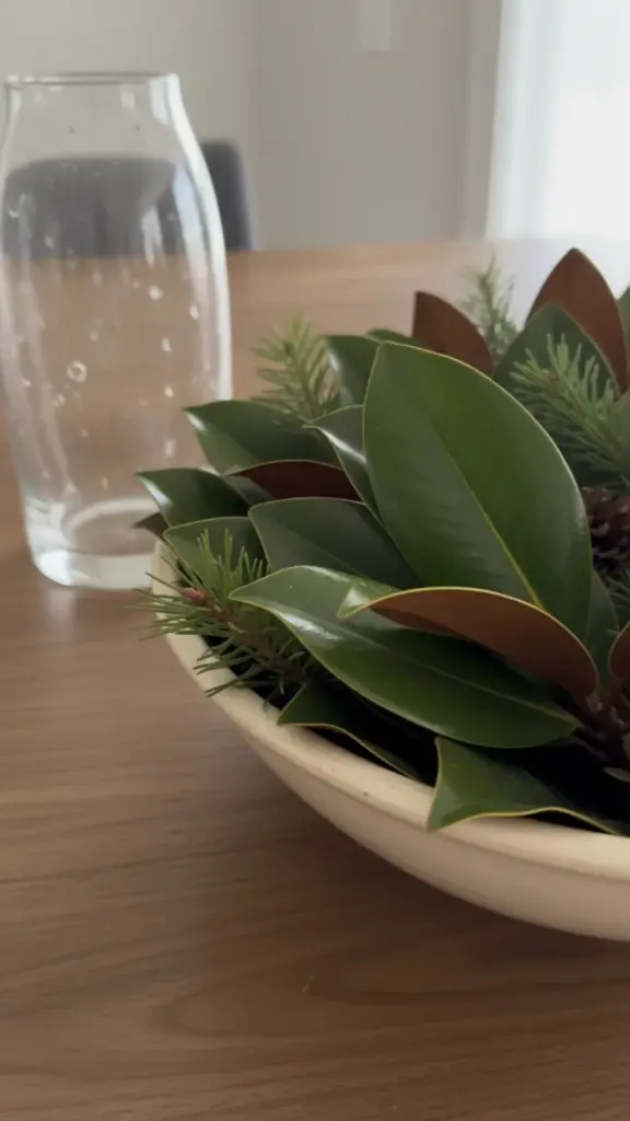 Wide bowl of glossy magnolia leaves mixed with pine, sap wiped from the needles