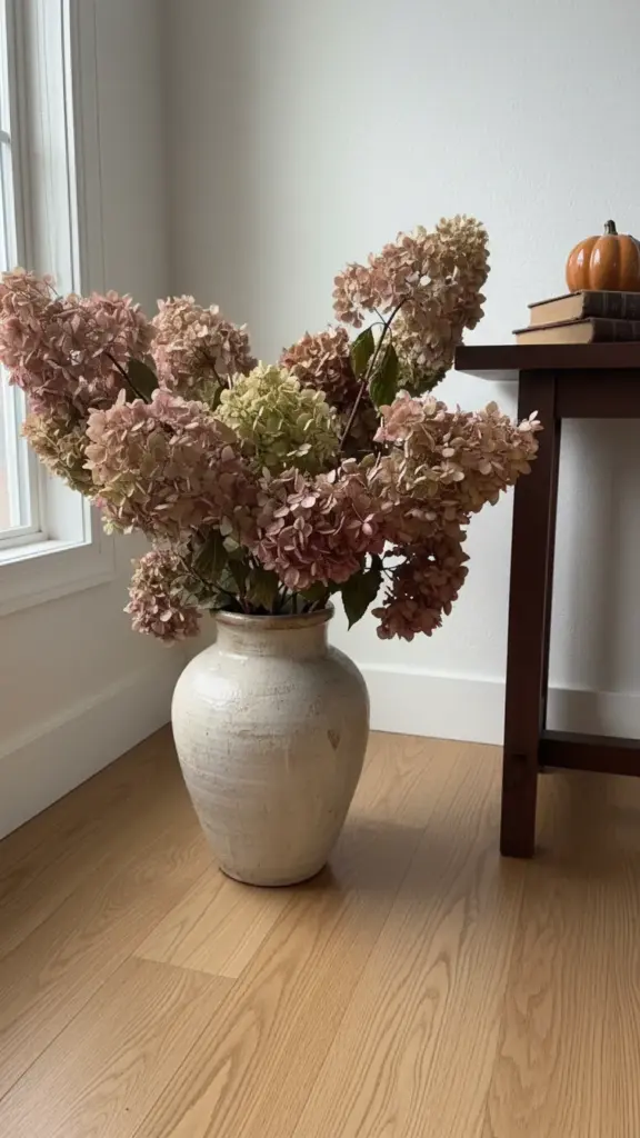 Dried hydrangea bunches in a floor vase in the entryway