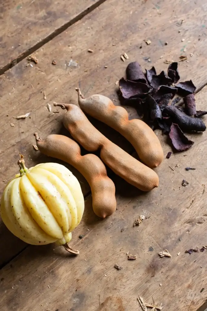 Kudampuli fruit, tamarind pods and kokum rind laid side by side on a table