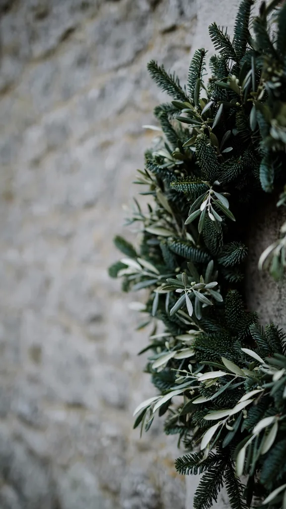 Pale olive branches with small oval leaves mixed into a dark fir wreath