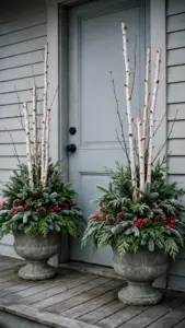 A matched pair of Christmas urns flanking a front door with evergreen boughs and berries.