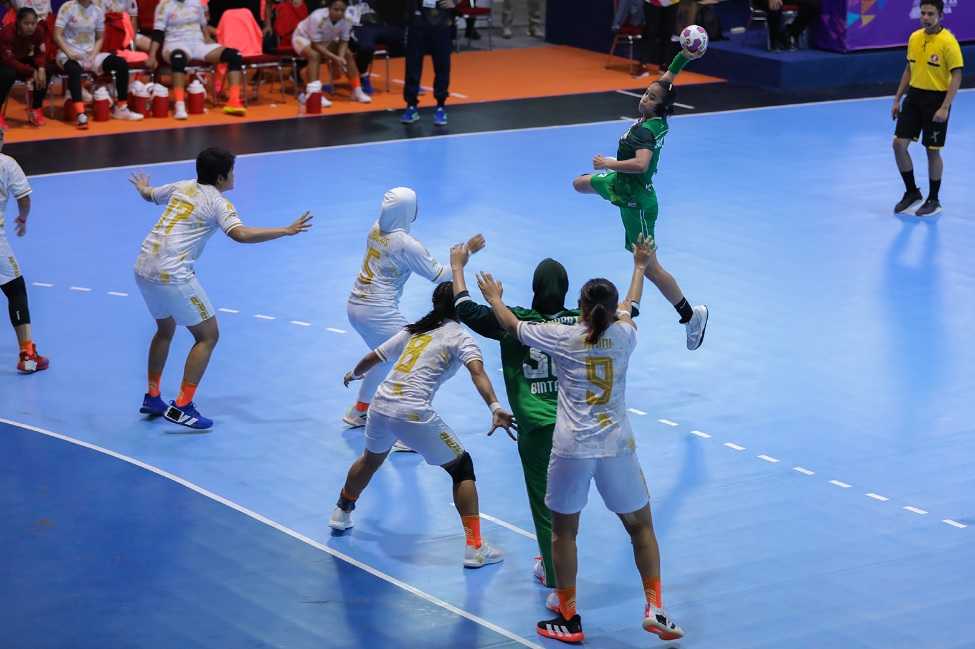 Aksi Pemain Lia Apriliani (kanan) Jawa Barat melempar bola sambil melompat melawan DKI Jakarta dalam babak penyisihan Cabang Olahraga Bola Tangan Putri.