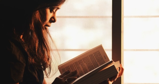 Seorang perempuan sedang membaca buku