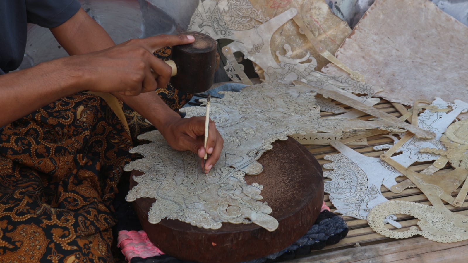 Anom sedang melakukan proses pemahatan wayang