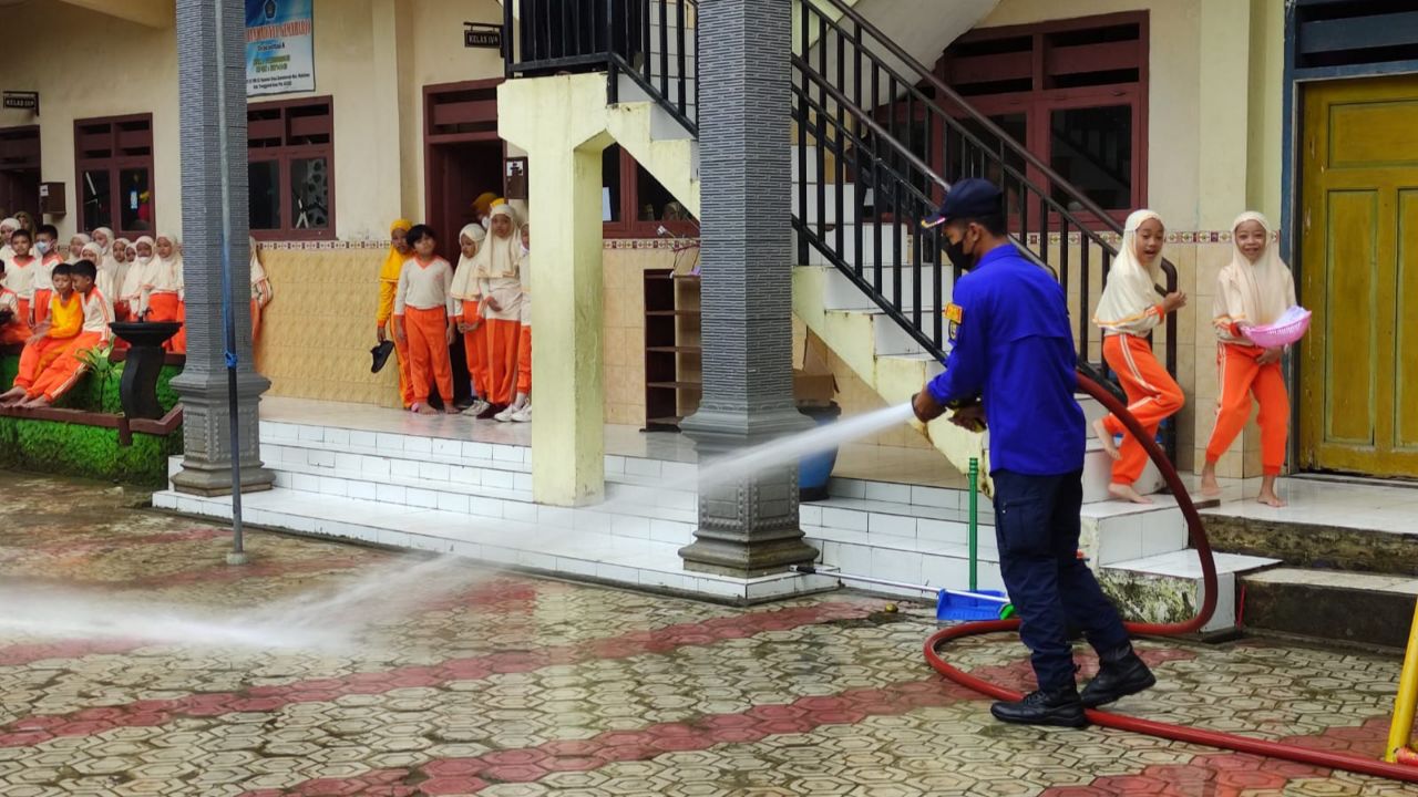 Damkar Trenggalek Bersihkan Sisa Lumpur Banjir di Halaman MI Muhammadiyah Watulimo