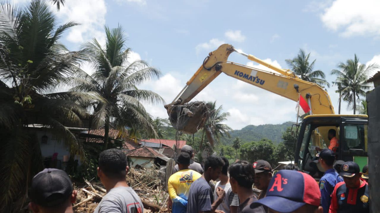 Ekskavator membersihkan material sisa banjir di Watulimo