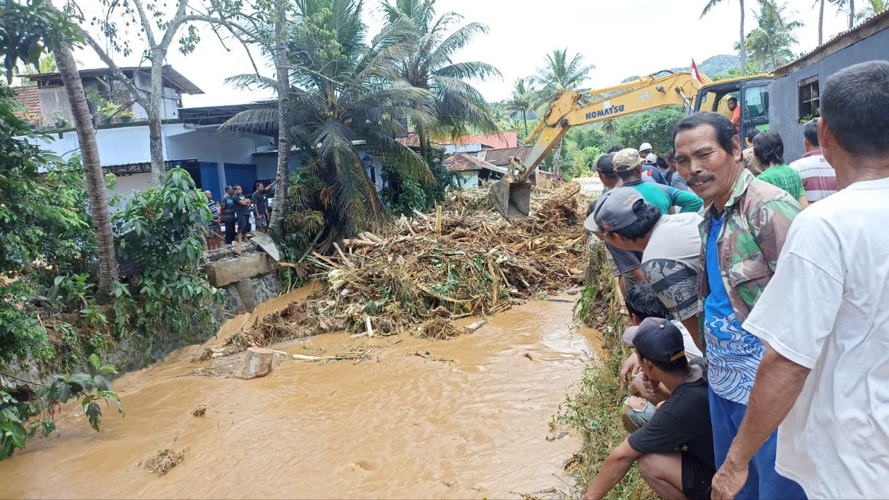 Proses pembersihan material sisa banjir di jembatan Watulimo