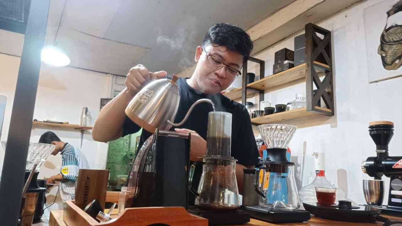 Pandu Budi Wicaksono menuangkan air panas ke alat penyaringan berisi bubuk kopi | Foto @mastrigus-KBRT
