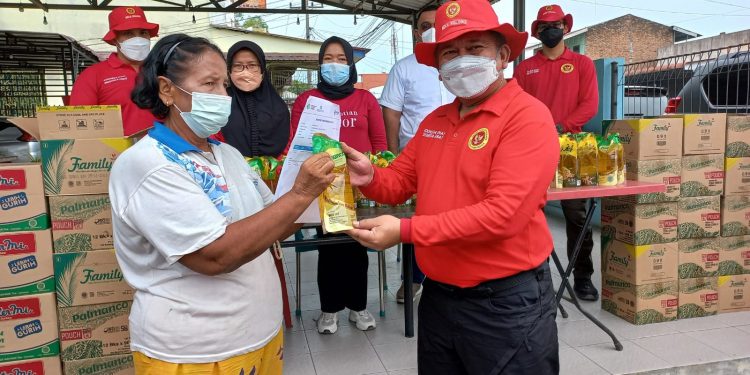 Ka. BINda Sumut Brigjen TNI Asep Jauhari Puja Laksana menyerahkan sertifikat vaksin dan minyak goreng pada ibu lansia peserta vaksin Binda Sumut, Minggu (27/3).