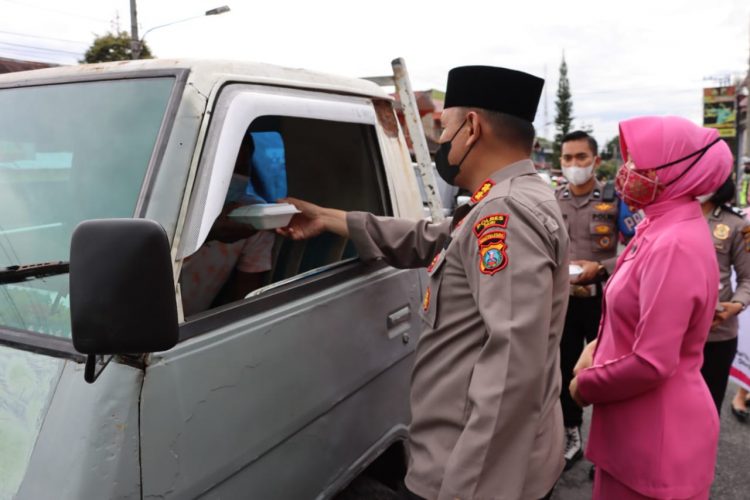 Kapolres Dairi, AKBP Wahyudi didampingi Kepala Cabang Bhayangkari Dairi saat berbagi takjil dan nasi kotak berbuka puasa, Senin (11/4).