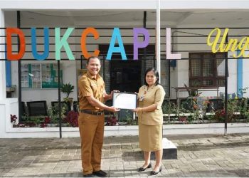 Kadis Dukcapil Dairi, Deddy Situmorang saat menyerahkan penghaaan, Senin (18/4).