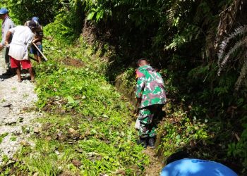 Personel Koramil 04/ Tigalingga, Serka Imanuel Ginting melaksanakan gotongroyong bersama masyarakat Dusun Pertumbungen, Jumat (22/4).