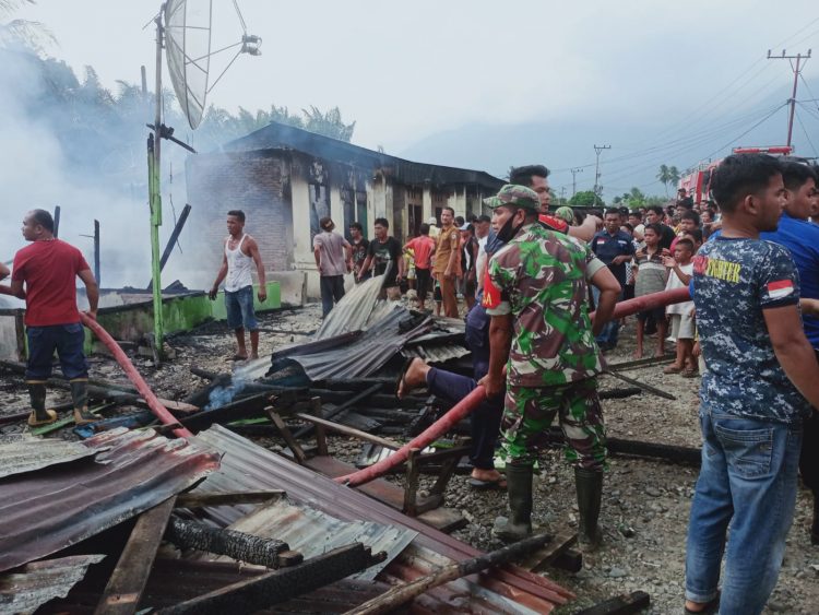 Babinsa Koramil 01/ Lawe Sigalagala saat evakuasi dan bantu warga membersihkan puing kebakaran hanguskan 7 rumah warga, Selasa (26/4).