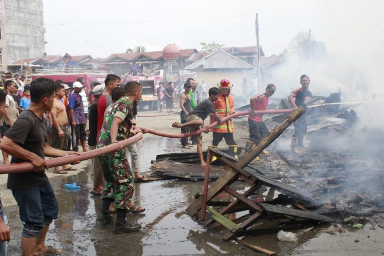 TNI, Petugas Damkar dan masyarakat saat berupaya memadamkan api yang menghanguskan 12 unit rumah, Kamis (28/4).