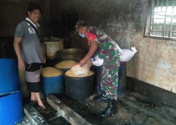 Anggota Koramil 04/ Babussalam, Sertu Dedi Susilo saat bantu warga UMKM, Selasa (10/5).