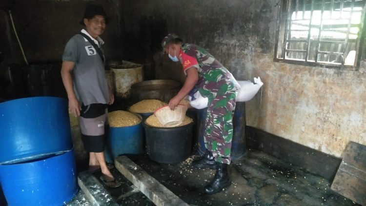 Anggota Koramil 04/ Babussalam, Sertu Dedi Susilo saat bantu warga UMKM, Selasa (10/5).