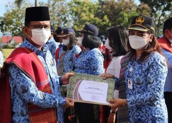 Bupati Toba, Poltak Sitorus saat menyeragkan penghargaan kepada guru saat peringatan Hardiknas, Jumat (13/5).