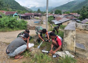 Serma Wanda Rumah Horbo bersama warga saat bersihkan parit, Sabtu (14/5).