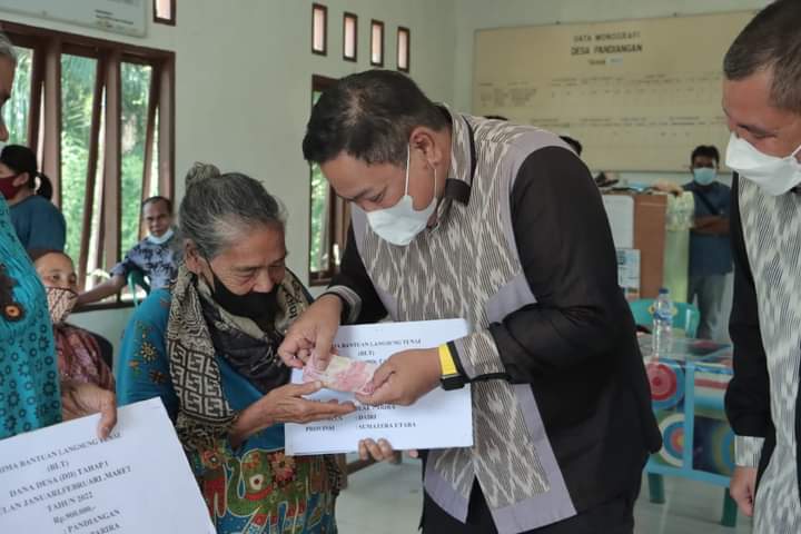 Bupati Dairi, Eddy KA Berutu saat menyerahkan BLT DD bagi warga, Sabtu (14/5).