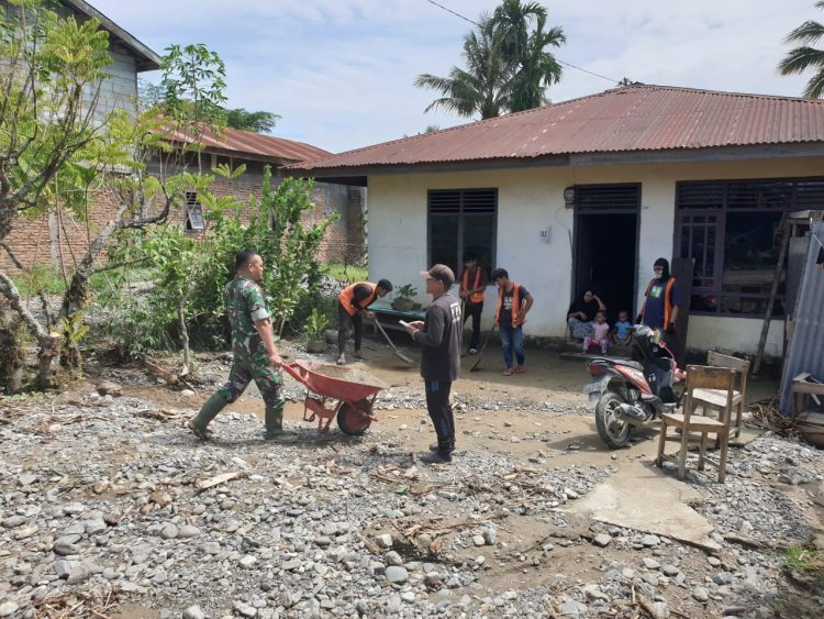 Anggota Koramil 02/ Bambel jajaran Kodim 0108/ Agara saat bergotongroyong bersama warga bersihkan material pasca banjir, Selasa (17/5).