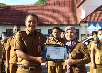 Kadis Dukcapil Dairi, Deddy Situmorang saat memberikan penghargaan kepada pegawai teladan, Asrina Daulay, Senin (23/5).