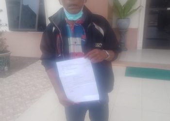 Maringan Napitupulu saat menunjukkan surat tanggapanya kepada PN Balige, Rabu (25/5).