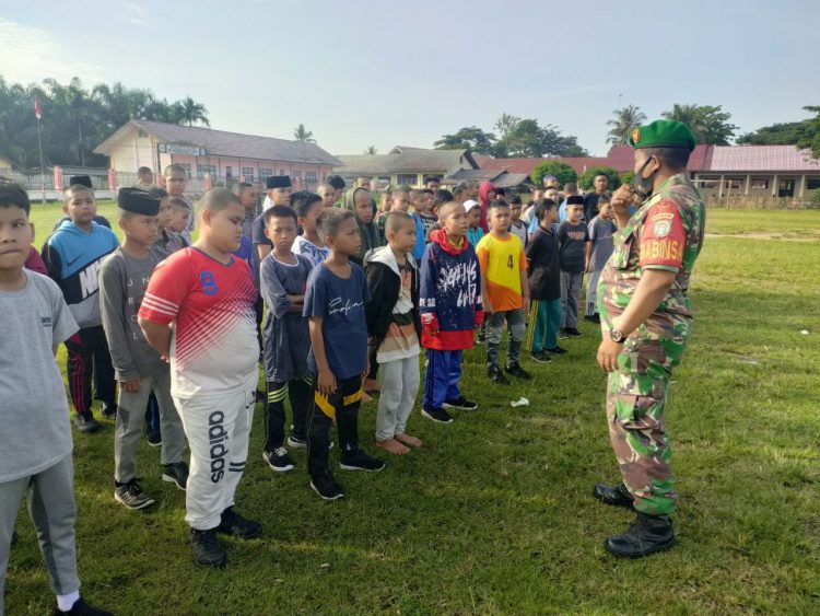 Babinsa Koramil 05/Lawe Alas jajaran Kodim 0108/ Agara, Koptu Jafarudin saat melatih santri dari pondok pesantren Darul Ulum bermain bola di Desa Cingkem Merangun, Kecamatan Lawe Alas Kabupaten Aceh Tenggara, Sabtu (28/5).