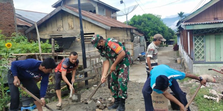 Babinsa Posramil Bukit Tusam, Sertu Basri Pohan ersama warga saat perbaiki jalan rusak, Senin (6/6).