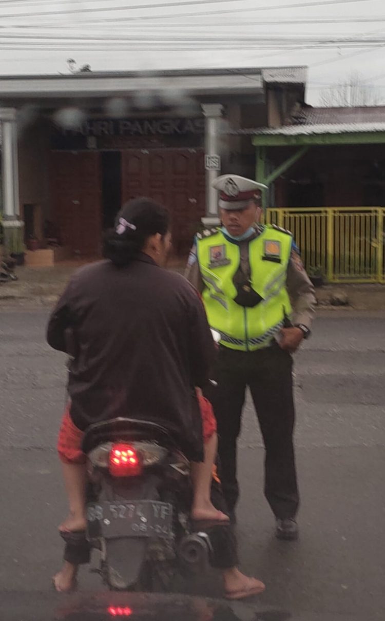 Aiptu Niko Pardosi Personil Satlantas Polres Dairi saat mengamankan seorang pengendara yang tidak menggunakan helm,di persimpangan Jalan Ahmad Yani - Kota Sidikalang, Rabu(5/6).
