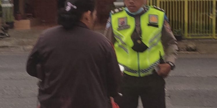 Aiptu Niko Pardosi Personil Satlantas Polres Dairi saat mengamankan seorang pengendara yang tidak menggunakan helm,di persimpangan Jalan Ahmad Yani - Kota Sidikalang, Rabu(5/6).