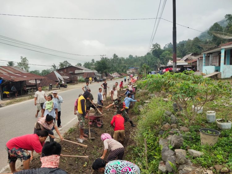 Personil Koramil 01/ Lawe Sigalagala bersama warga Desa Lawe Tua Makmur saat bergotongroyong bersihkan saluran parit, Kamis (23/6).