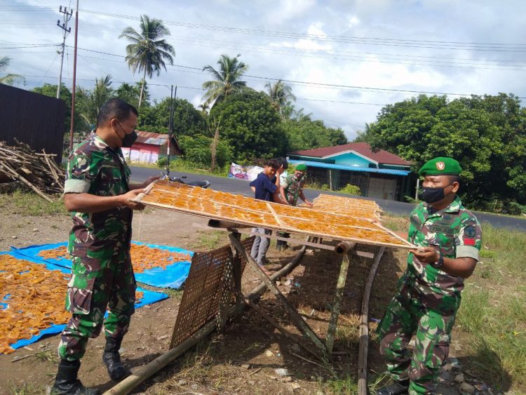 Sertu Daniel Hutagalung bersama rekan Babinsa Posramil Babul Makmur saat komsos bantu jemur kerupuk, Jumat (24/6).