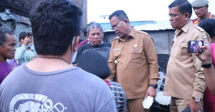 Bupati Toba, Poltak Sitorus bersama staf jajaran Pemkab Toba saat tinjau 3 rumah yang terbakar di Laguboti, Senin (27/6).