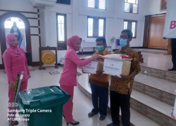 Ketua Bhayangkari Polres OKU Timur, Ny. Ana Nuryono saat menyerahkan bantuan kepada 
Ketua Stasi dan Pengurus Gereja Katholik Santo Pius X, Rabu (13/7).