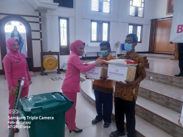 Ketua Bhayangkari Polres OKU Timur, Ny. Ana Nuryono saat menyerahkan bantuan kepada 
Ketua Stasi dan Pengurus Gereja Katholik Santo Pius X, Rabu (13/7).