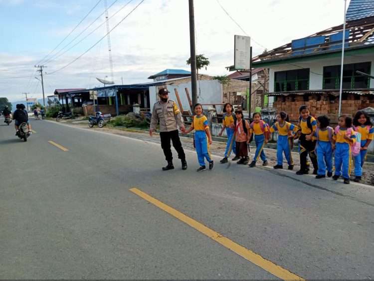 Personil Polres Dairi saat menyeberangkan siswa/i, Jumat (19/8).