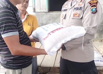 Kapolsek Tigalingga, AKP. SP Siringoringo SH saat menyerahkan bantuan berupa sembako kepada warga korban bencana alam angin puting beliung di Dairi, Jumat (19/8).