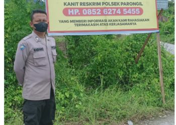 Kapolsek Parongil, AKP. HP Purba saat pasang spanduk, Selasa (23/8).
