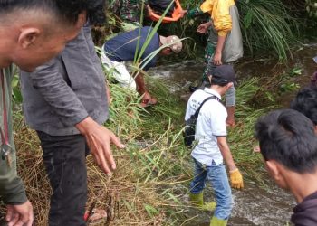 Personil Polsek Siborongborong bersama warga saat evakuasi mayat Johan dialiran Sungai, Senin (29/8).