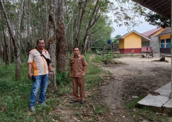 Kepsek SDN 01 Totorejo, Sarono bersama reporet Indigonews saat tinjau lahan yang dikuasi Sarmin, Senin (19/9).