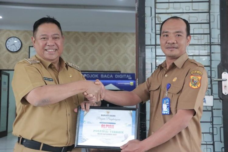 Bupati Dairi, Dr. Eddy Berutu saat memberikan penghargaan kepada Kadis Dukcapil Dairi, Dedy Situmorang atas kinerja, Senin (3/10).