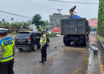 Kasat Lantas Polresta Deliserdang, Kompol. Nasrul S.Kom SIK bersama jajaran saat menimbun lubang dibahu jalan Lubuk Pakam - Medan, Selasa (15/11).
