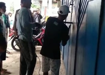 Petugas Polsek Wonopringgo bersama warga saat buka paksa pintu besi Toko, Rabu (23/11).