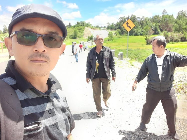 Reporter Indigonews bersma sejumlah warga terdampak pembangunan jalan lingkar Soekarno yang belum mendapat ganti untuk, saat berada di bangunan jalan lingkar Soekarno Siborongborong, Sabtu (26/11).