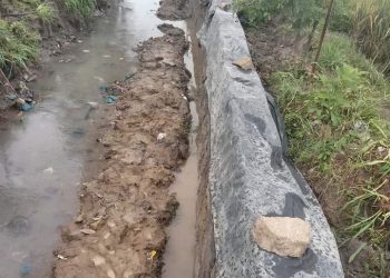 Kondisi pembangunan dinding saluran drainase tanpa pondasi dan pada genangan air, Jumat (9/12).