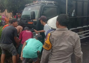 Warga saat mengevakuasi korban tabrakan yang terpental ke sungai, Minggu (18/12).