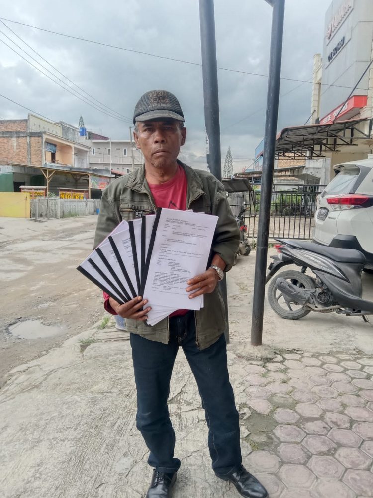 Maringan Napitupulu saat menunjukkan berkas aduanya ke Ombusman RI, Selasa (3/1).