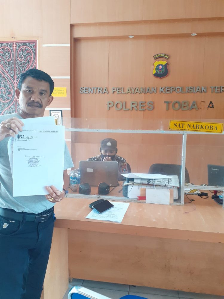 Djonggi Napitupulu yang juga keluarga Pelapor Jhon Ferry Simanjutak menunjukkan bukti laporan, Selasa (17/1). 