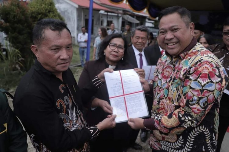 Bupati Dairi, Eddy Begitu saat menyerahkan sertifikat tanah milik GMI Lae Mbulan, Minggu (12/2).